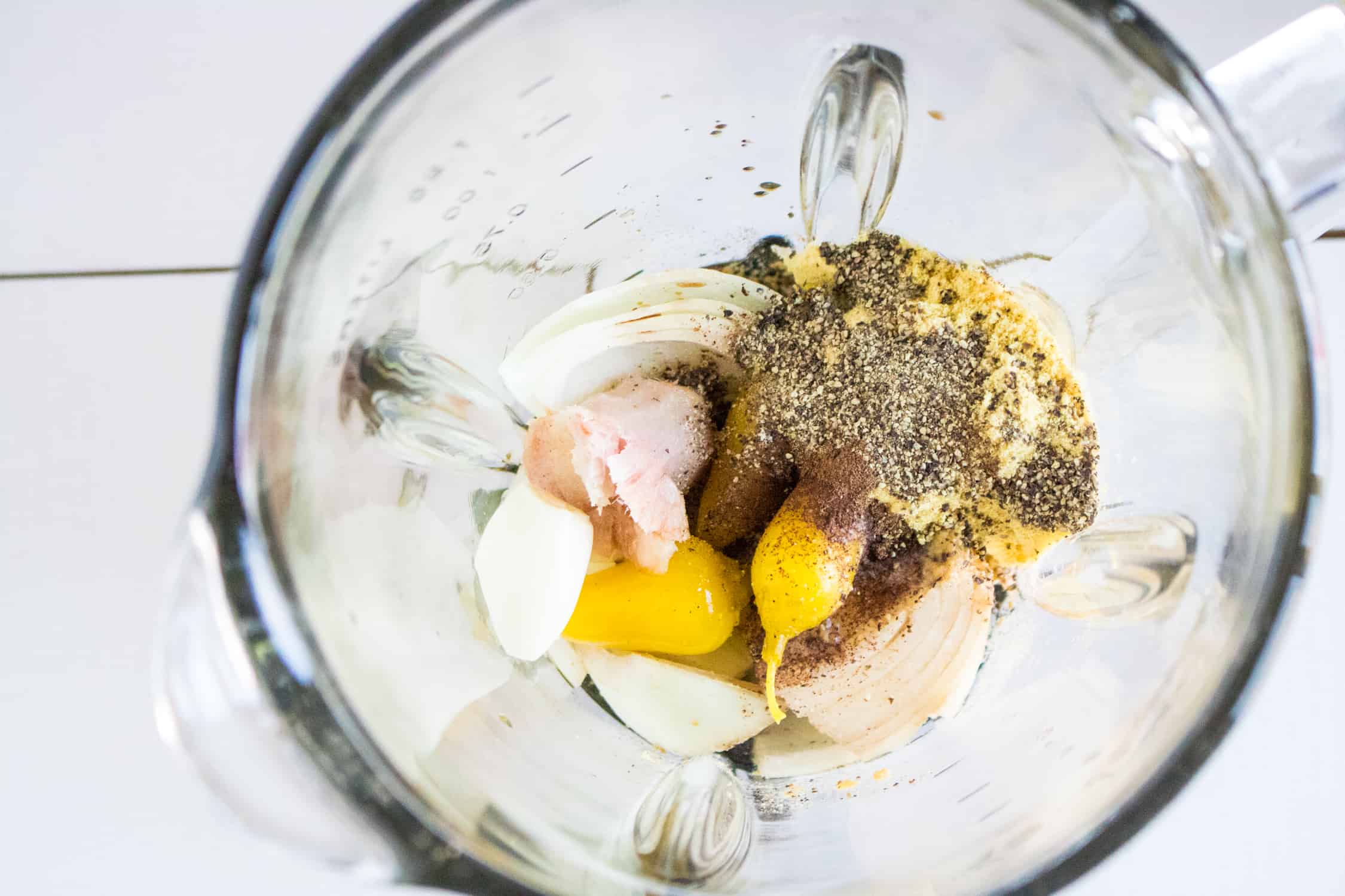 top-down view of all the jerk sauce ingredients inside a blender pitcher