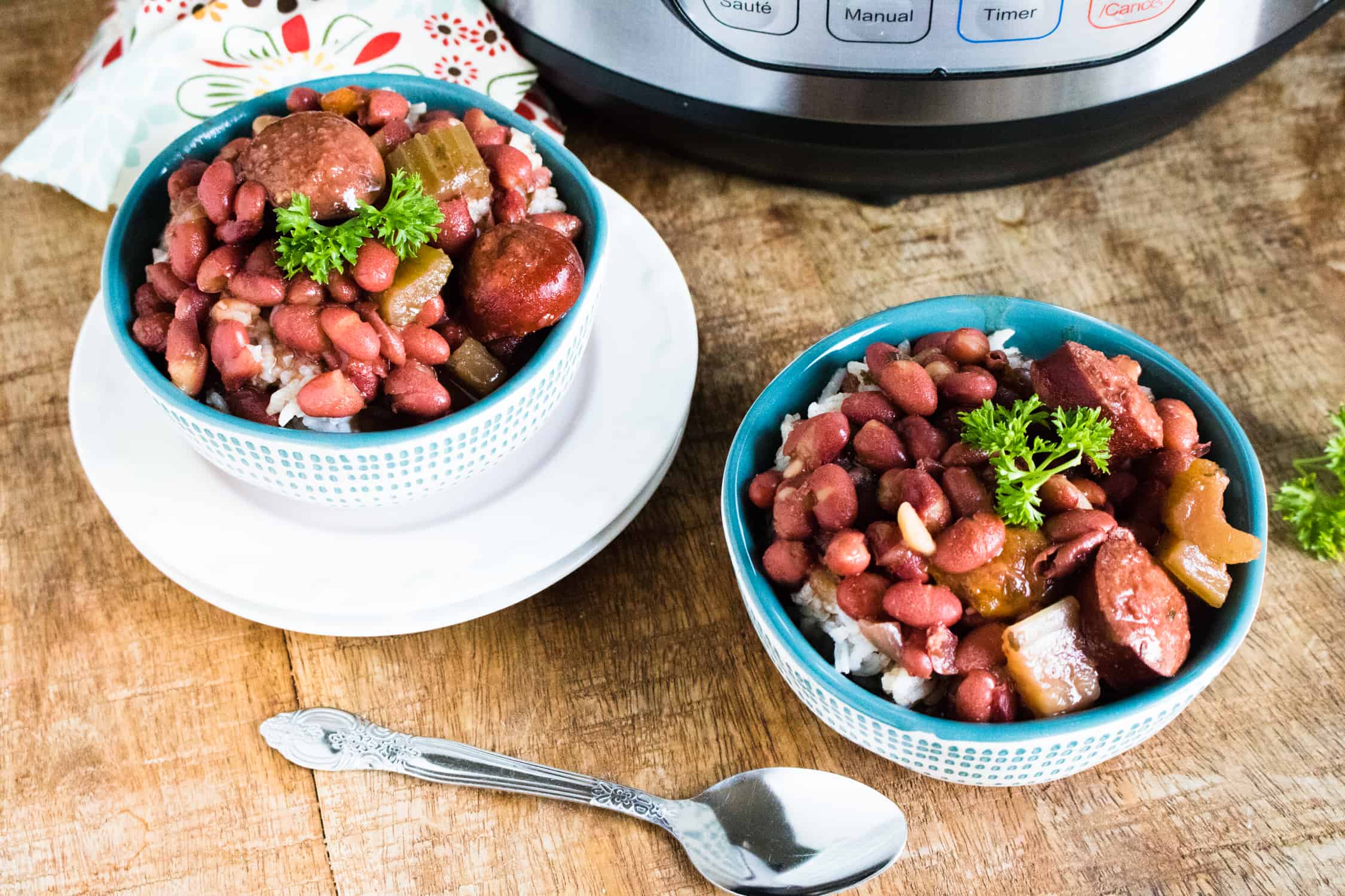 Two portions of Instant Pot Red Beans and Rice Recipe served over white rice in white and blue bowls