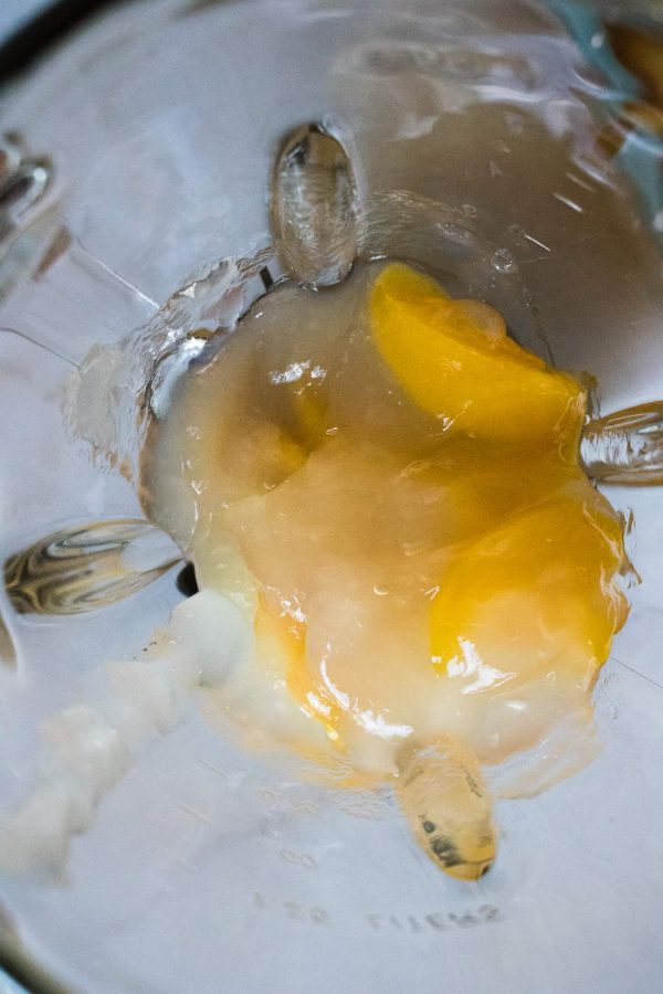 Peach pie filling and heavy cream in a glass blender jar before blending