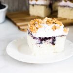 Permalink to: Blueberry Buckle Poke Cake A slice of Blueberry Buckle Poke Cake served on a white plate