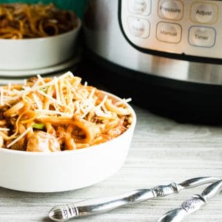 Instant Pot Baked Spaghetti served in a white bowl next to two silver forks