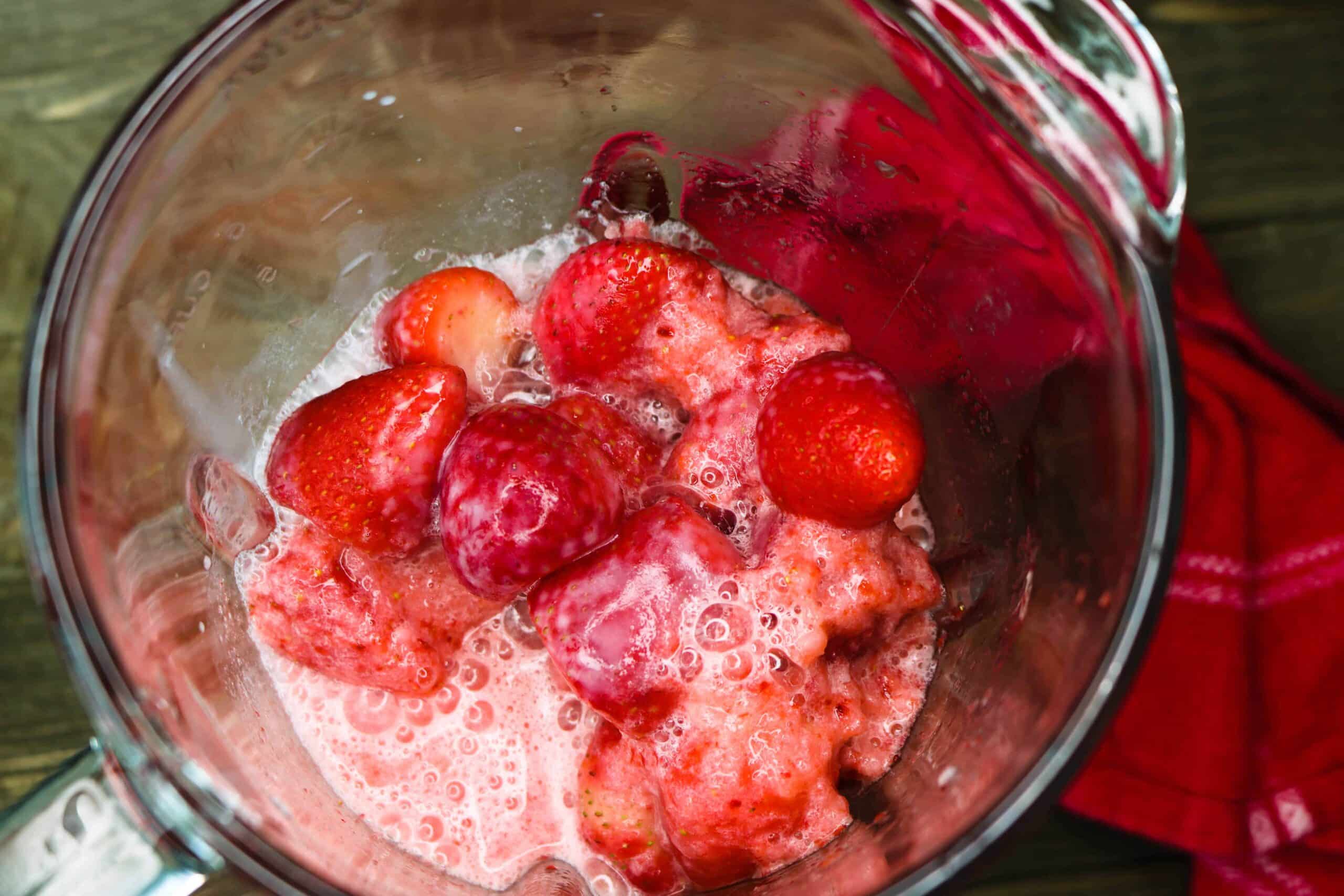 Strawberries, lemon juice and almond milk inside a blender