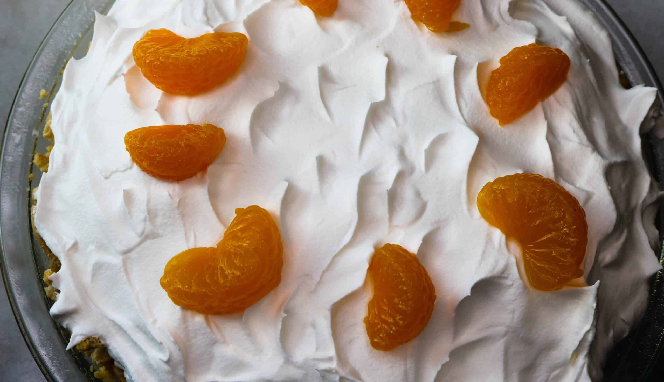 Third layer of smooth whipped topping added to the pie and topped with Mandarin orange slices