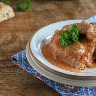 A serving of Instant Pot Pork Chops with Tomato Cream Sauce served on a white plate