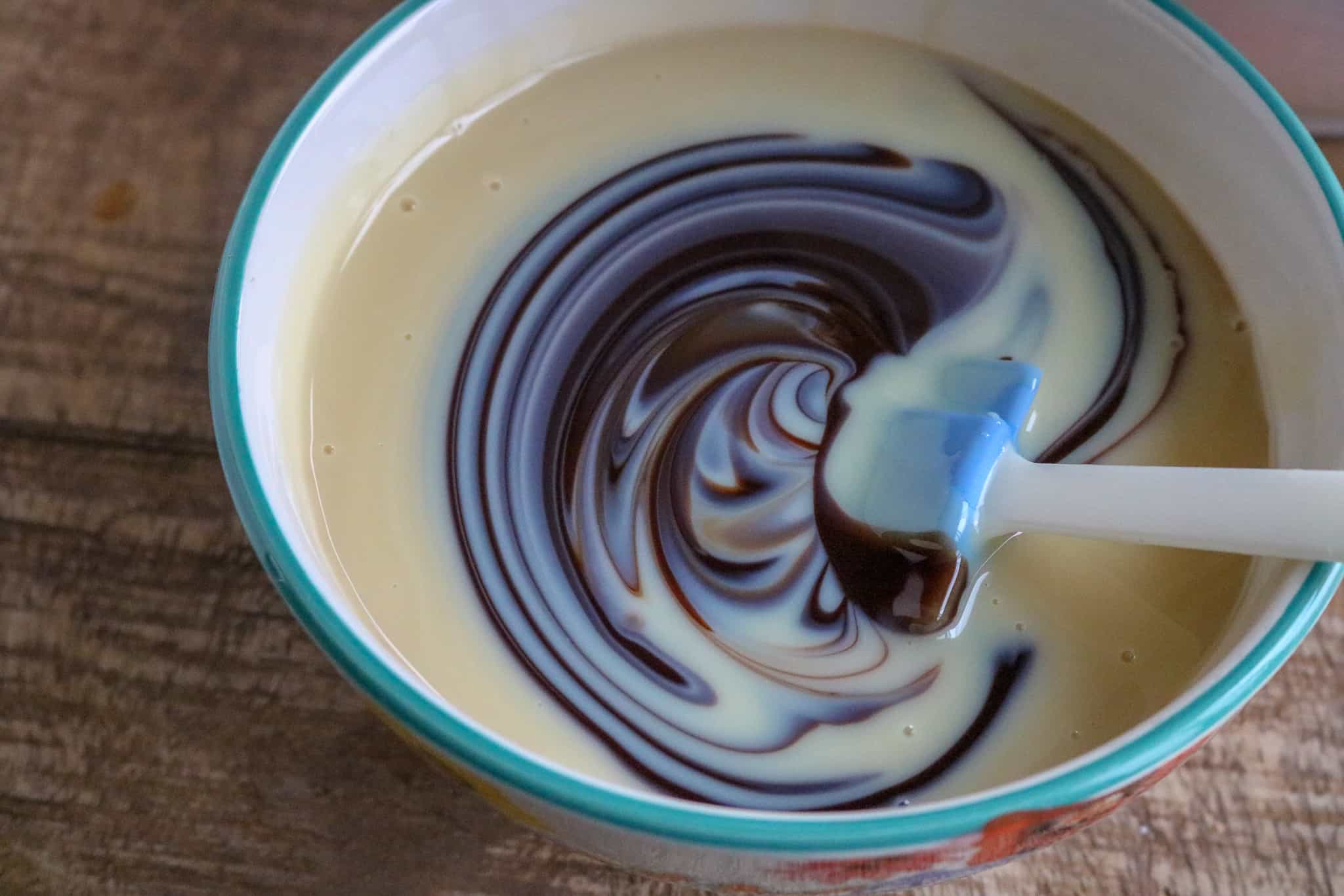 Mixing together the sweetened condensed milk and the chocolate syrup