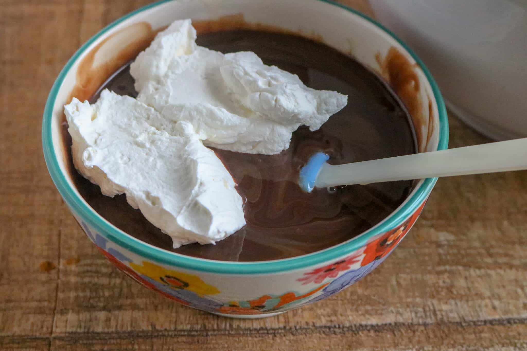 Adding the whipped cream to the sweetened condensed milk and chocolate syrup mixture.