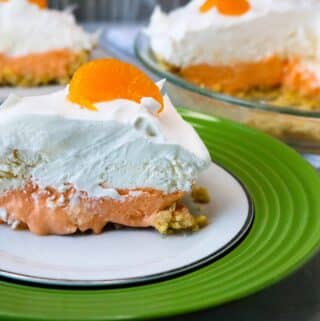 A slice of Boozy Orange Creamsicle Pie served on a green and white plate