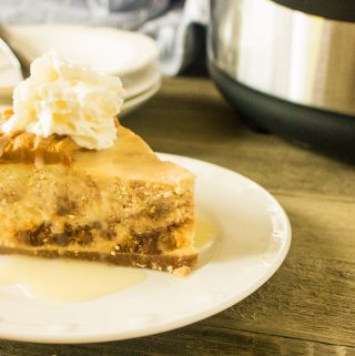 A slice of Instant Pot Peanut Butter Cheesecake served on a white plate and topped with whipped cream