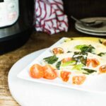 Instant Pot Caprese Frittata sliced and served on a white rectangular plate, and garnished with basil and cherry tomatoes