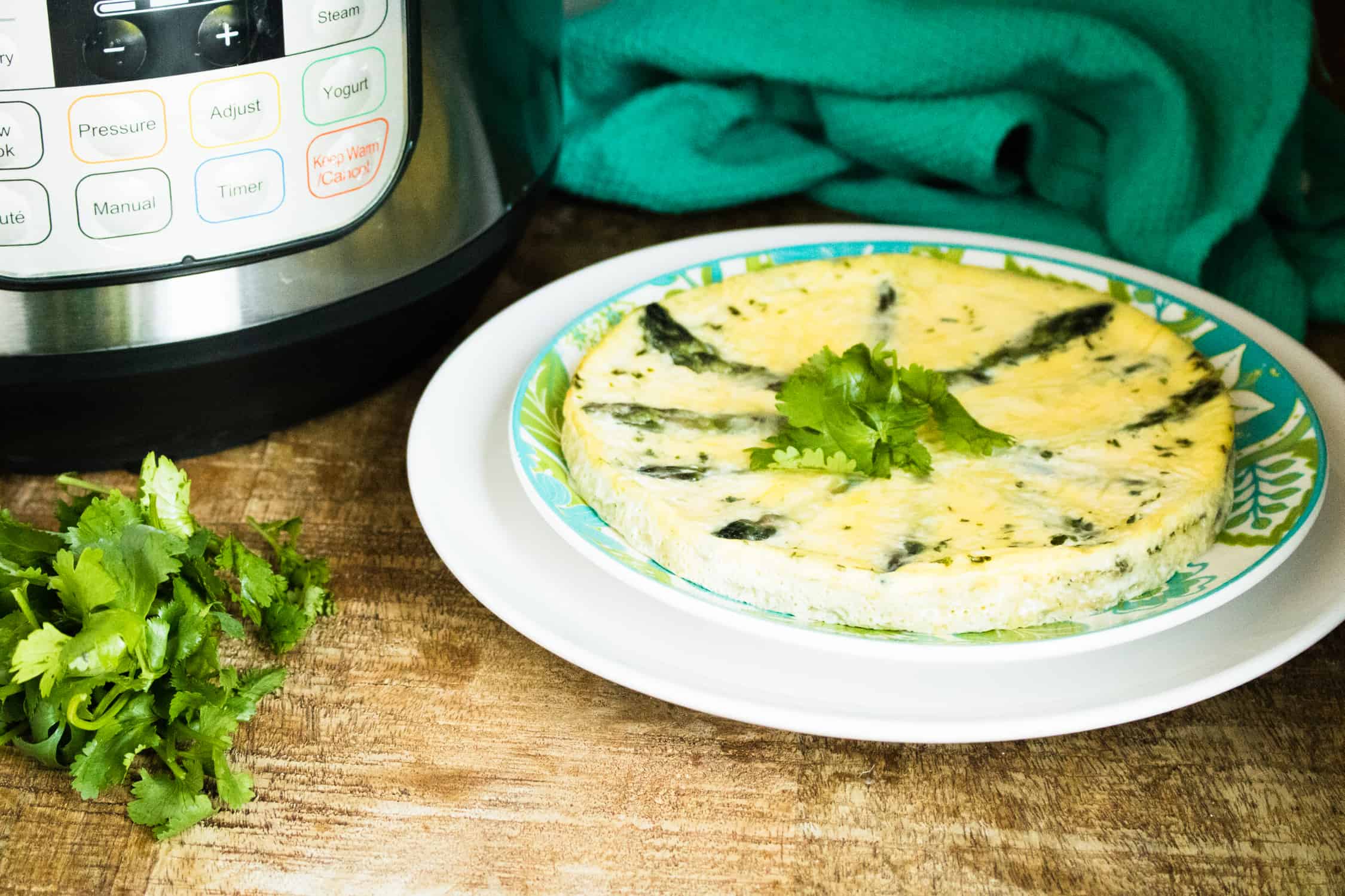 Instant Pot Asparagus Parmesan Frittata served on a blue print plate and garnished with parsley