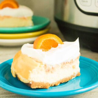 A slice of Instant Pot Orange Creamsicle Cheesecake served on a blue dessert plate