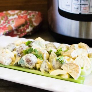 Instant Pot Heirloom Potato Salad on a bed of lettuce served on a white platter