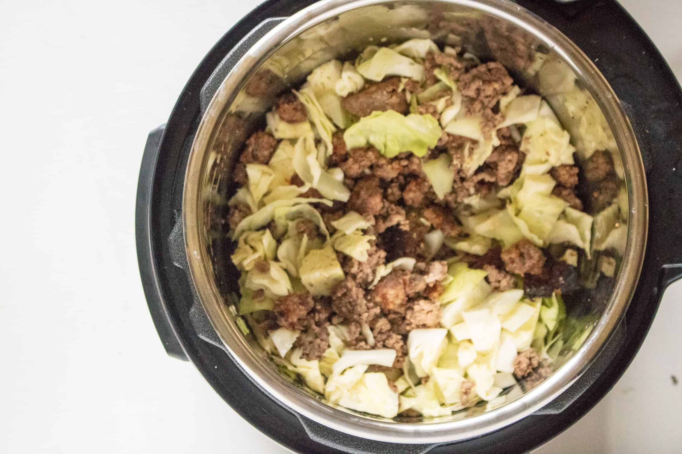 cut up cabbage, sausage and ground beef in an instant pot