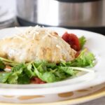 Instant Pot Cabbage Rolls served on a white plate and garnished with grated cheese and parsley