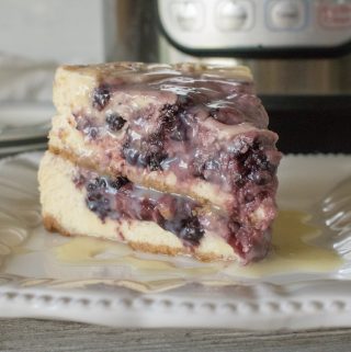 One slice of Instant Pot Blackberry Swirl Cheesecake served on a square white plate