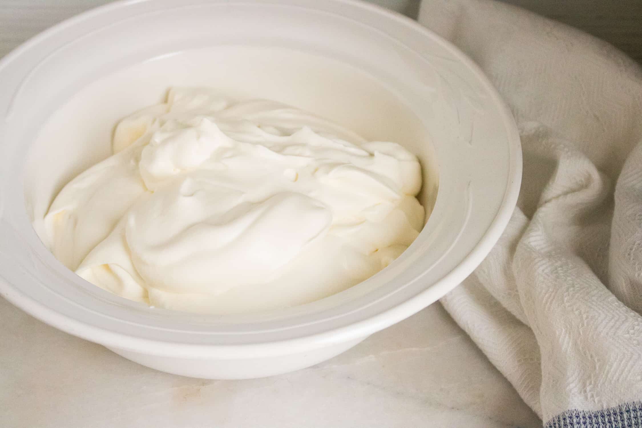 white mixing bowl filled with whipped heavy cream