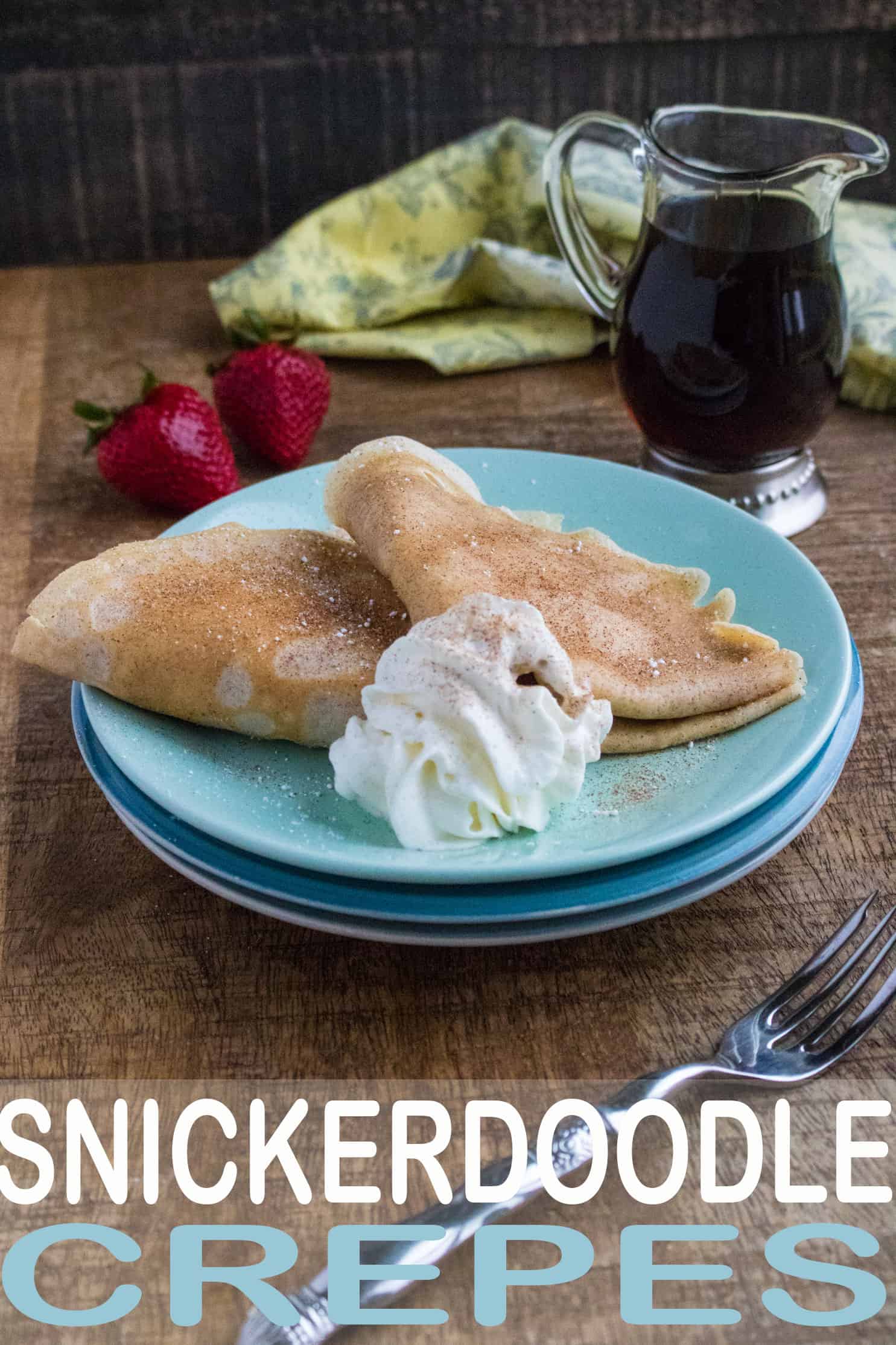 crepes with cinnamon and whipped topping on blue plates on top a wood tabletop