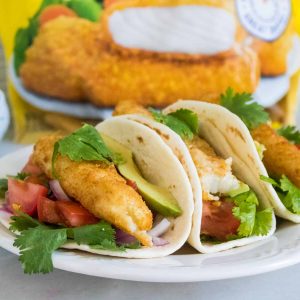 Three Crunchy Fish Tacos with Pico Sauce served on a white plate