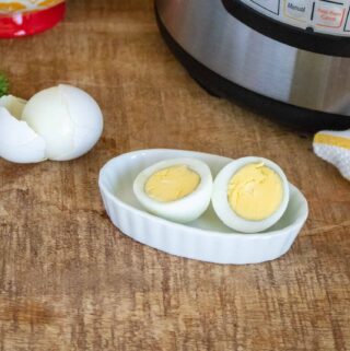 Two Instant Pot Hard-Boiled eggs peeled and served in a white ceramic dish