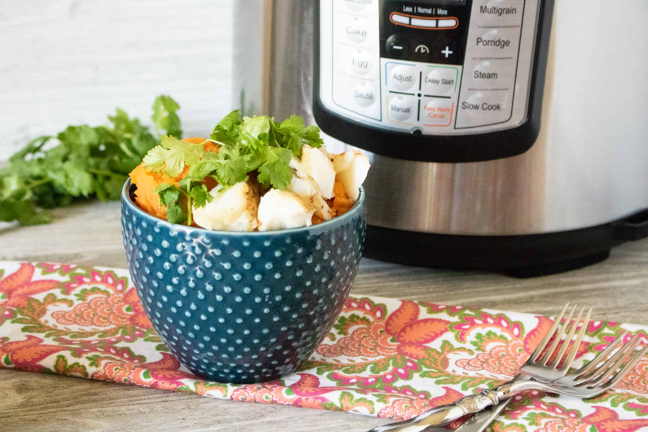 Instant Pot Cod fillets served in a blue polka dot bowl and garnished with parsley
