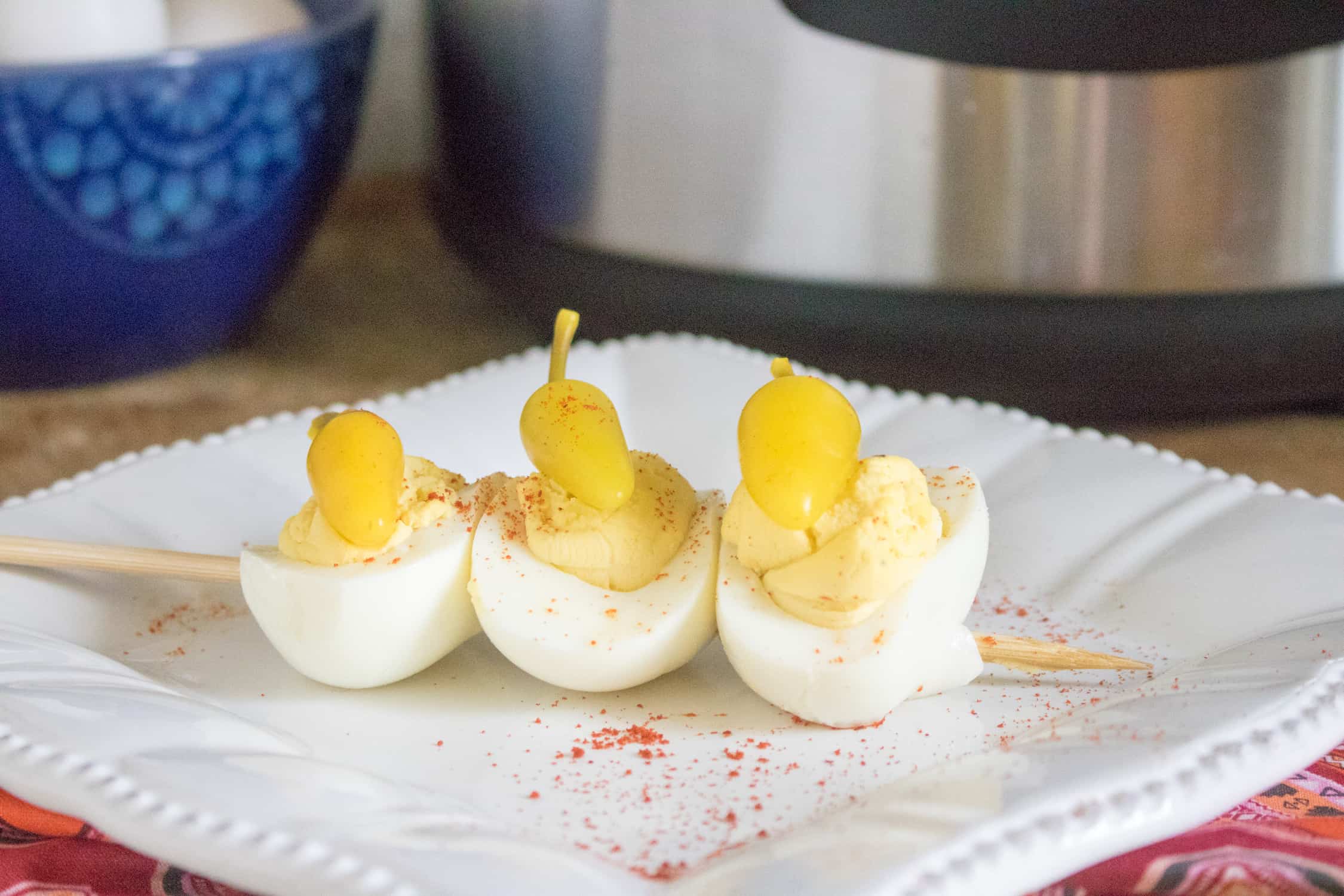 Instant Pot Deviled Eggs threaded on a skewer and served on a white plate