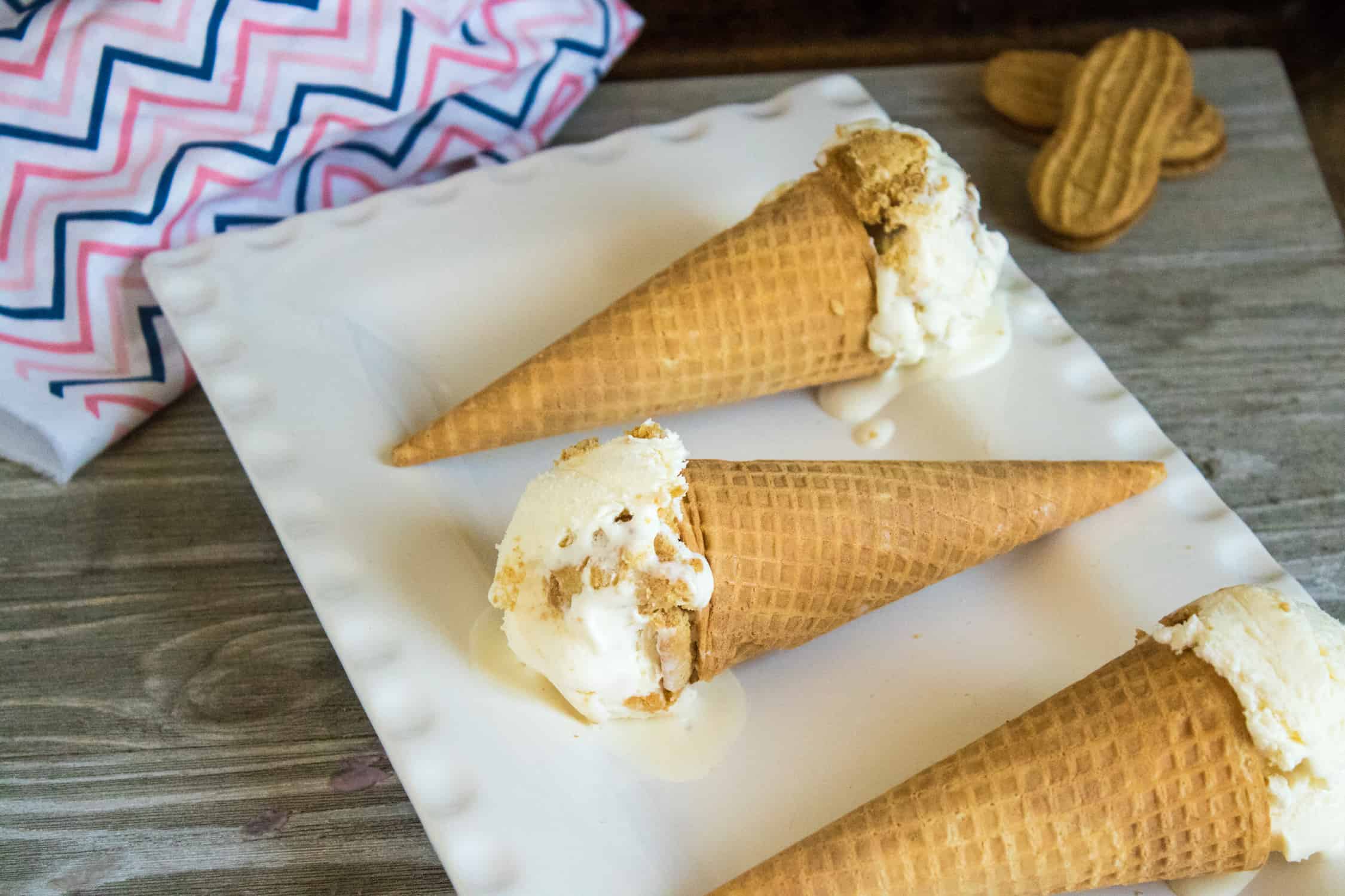 Nutter Butter No-Churn Ice Cream scooped into sugar cones and served on a white platter