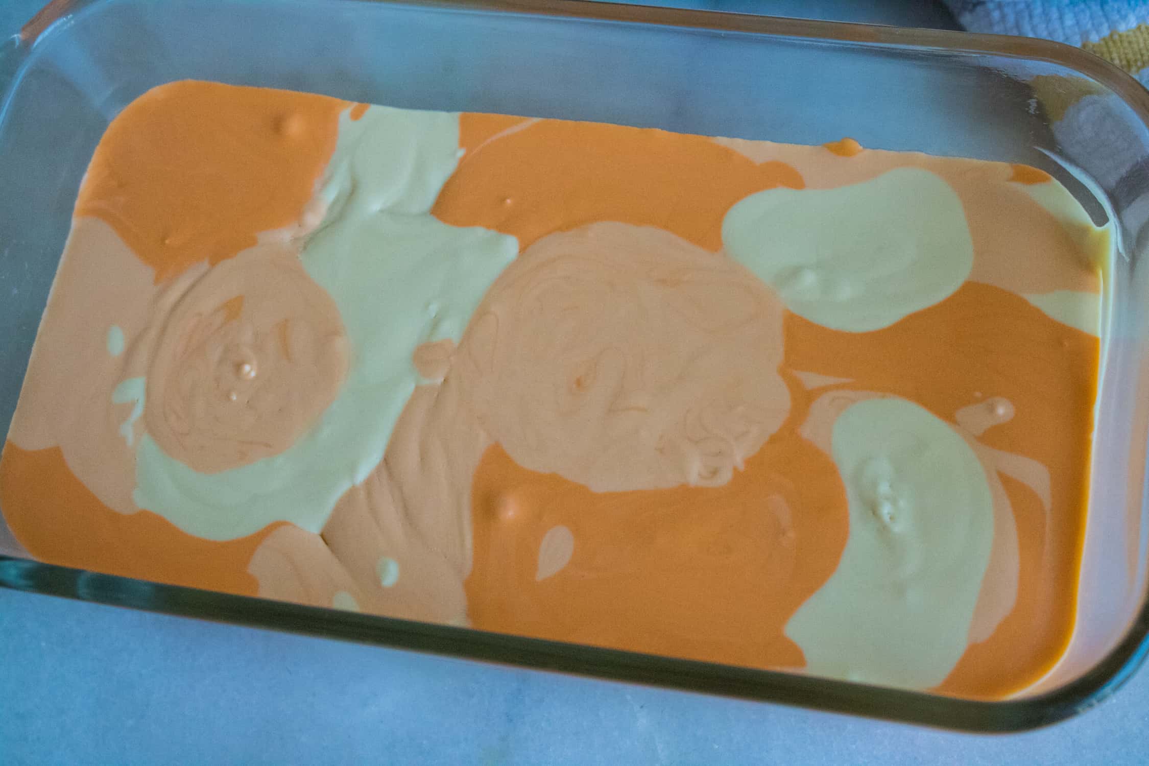 top-down view of the Orange Creamsicle No-Churn Ice Cream inside a glass bread pan