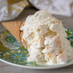Tropical No-Churn Ice Cream served with a sugar cone on a blue and green patterned plate