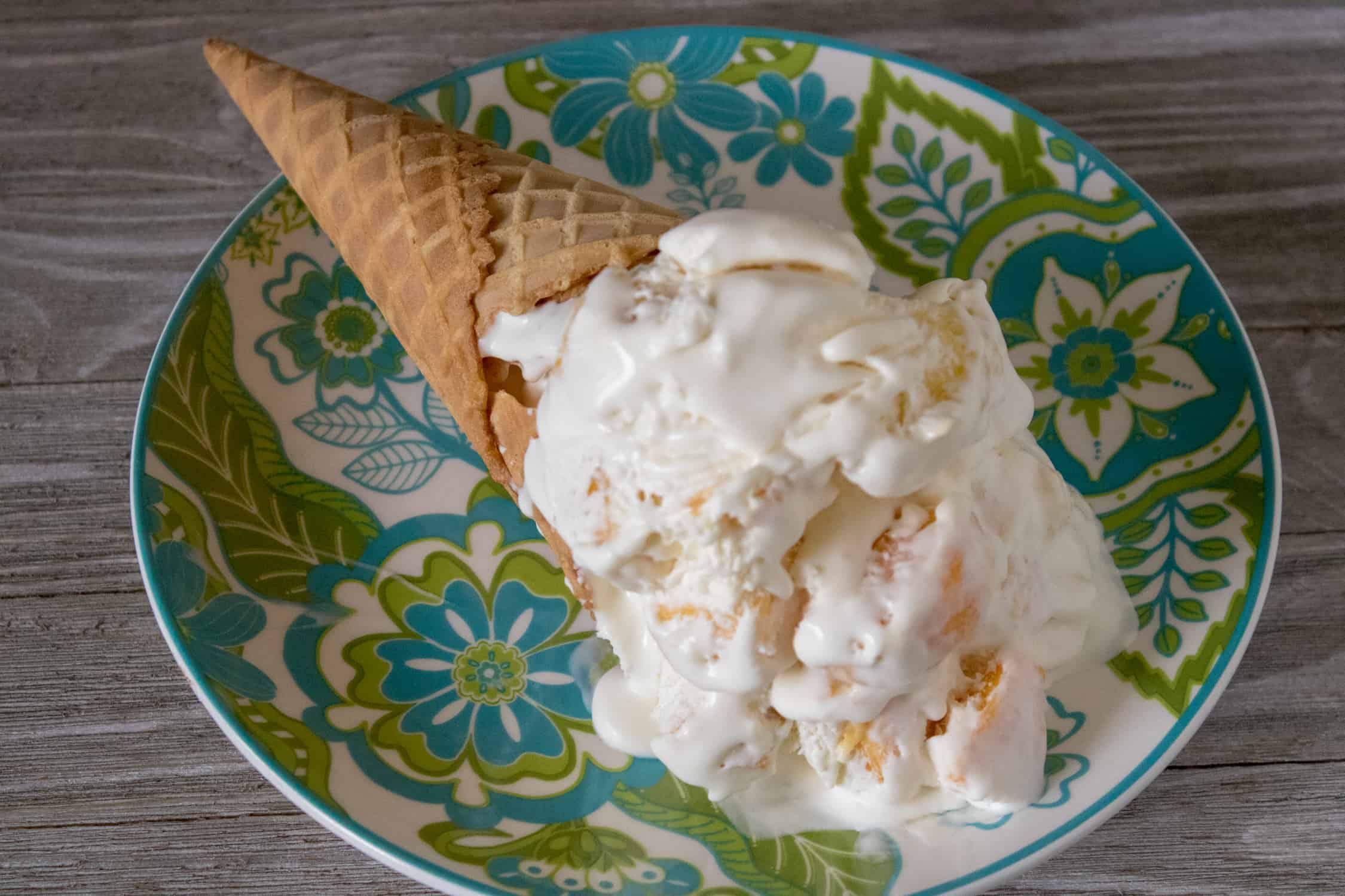 Tropical No-Churn Ice Cream served with a sugar cone on a blue and green patterned plate