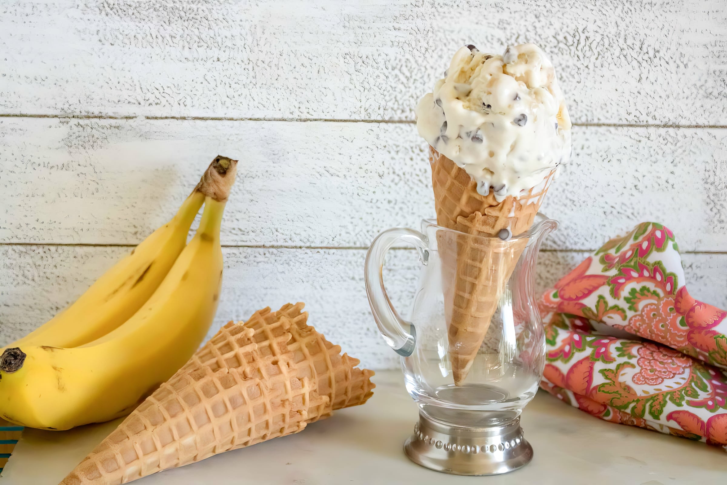 banana chocolate chip ice cream in a cone with bananas