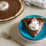 Permalink to: Easy Chocolate Cream Pie Recipe One slice of chocolate cream pie cut from the whole pie and served on a blue dessert plate and topped with whipped cream and shaved chocolate
