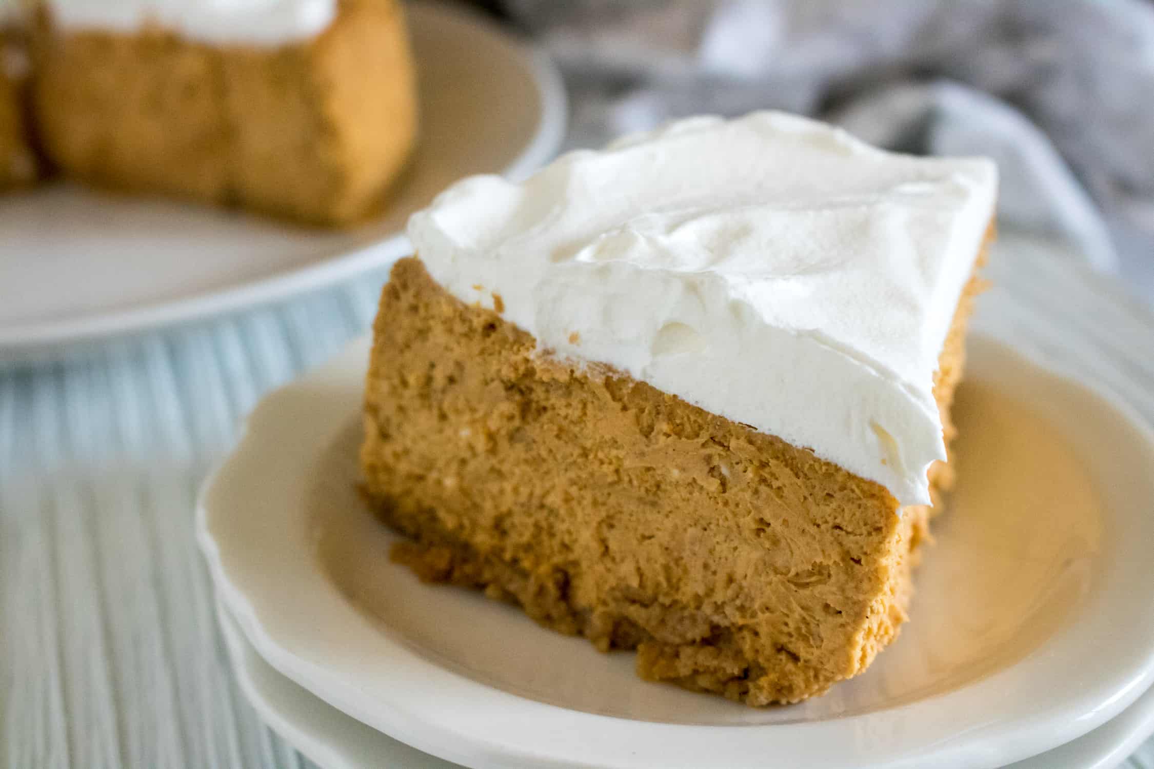 slice of Instant Pot Pumpkin Cheesecake sitting on a white plate