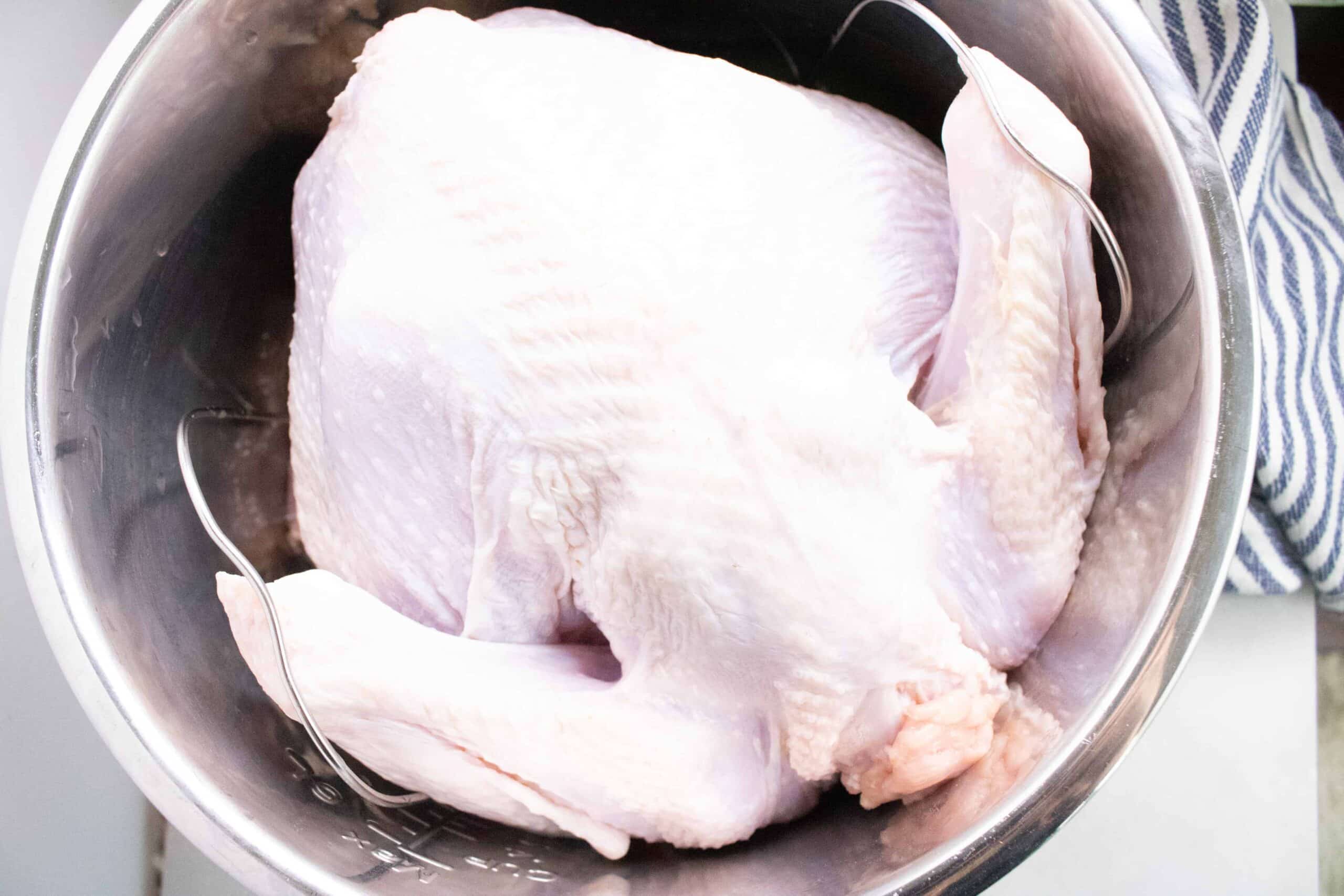 turkey placed on top of the trivet inside the Instant Pot insert