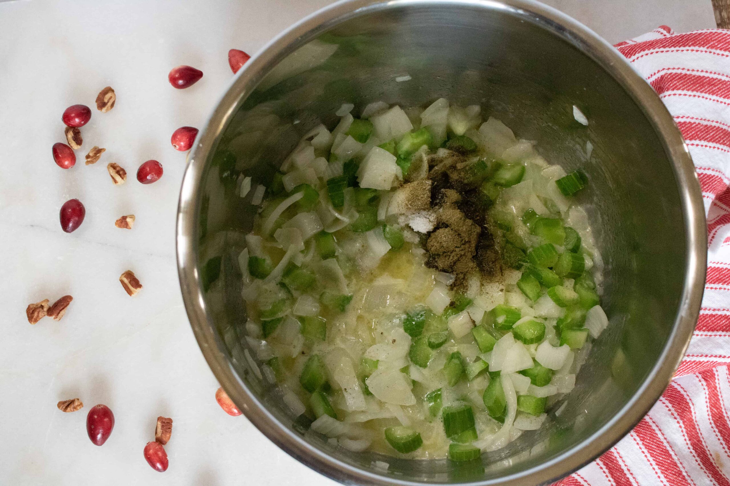 Diced onion, chopped celery, butter, and seasonings being sauted in the Instant Pot inner pot