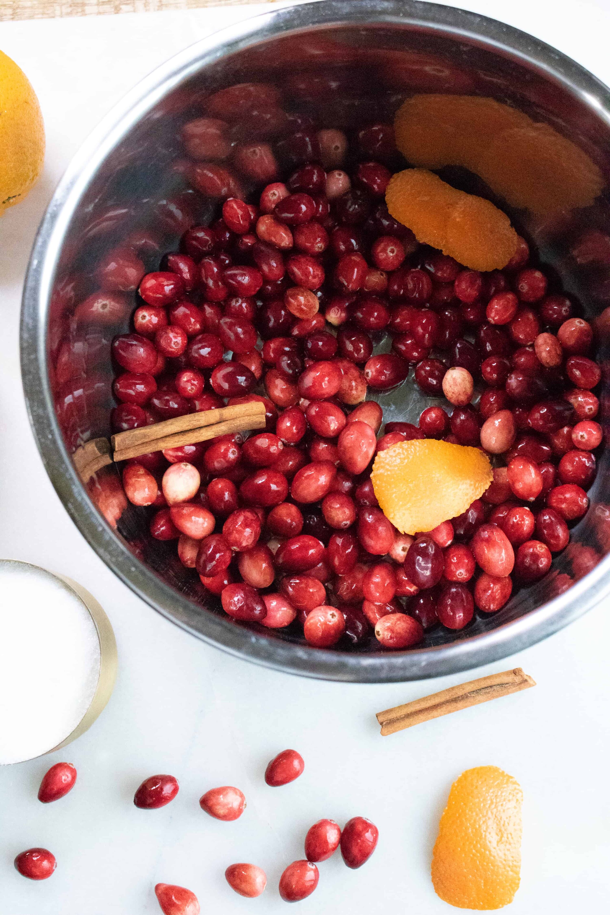 The ingredients for Instant Pot Cranberry Sauce being added to the Instant Pot inner pot