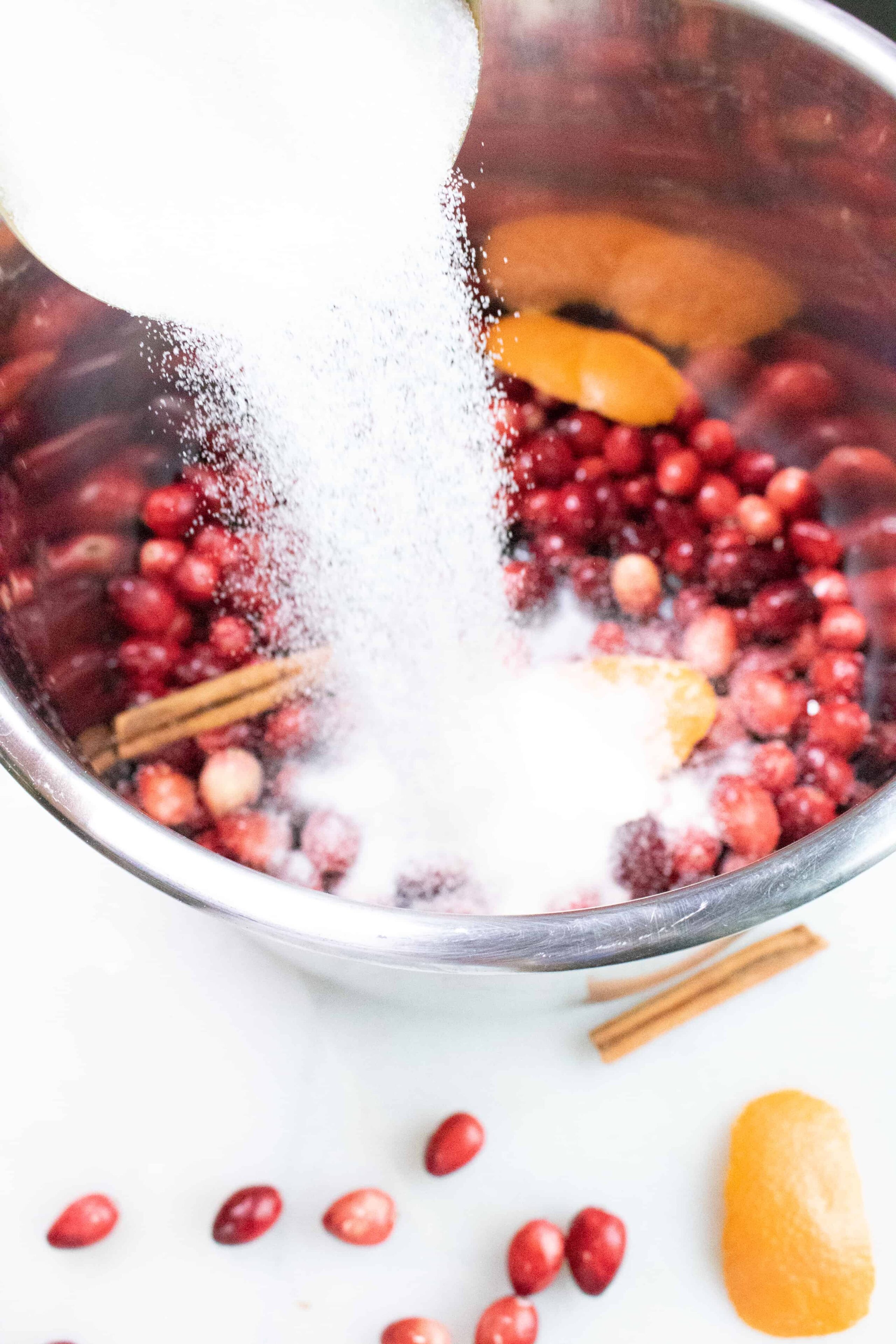 Ingredients for Instant Pot Cranberry Sauce being added to the Instant Pot inner pot
