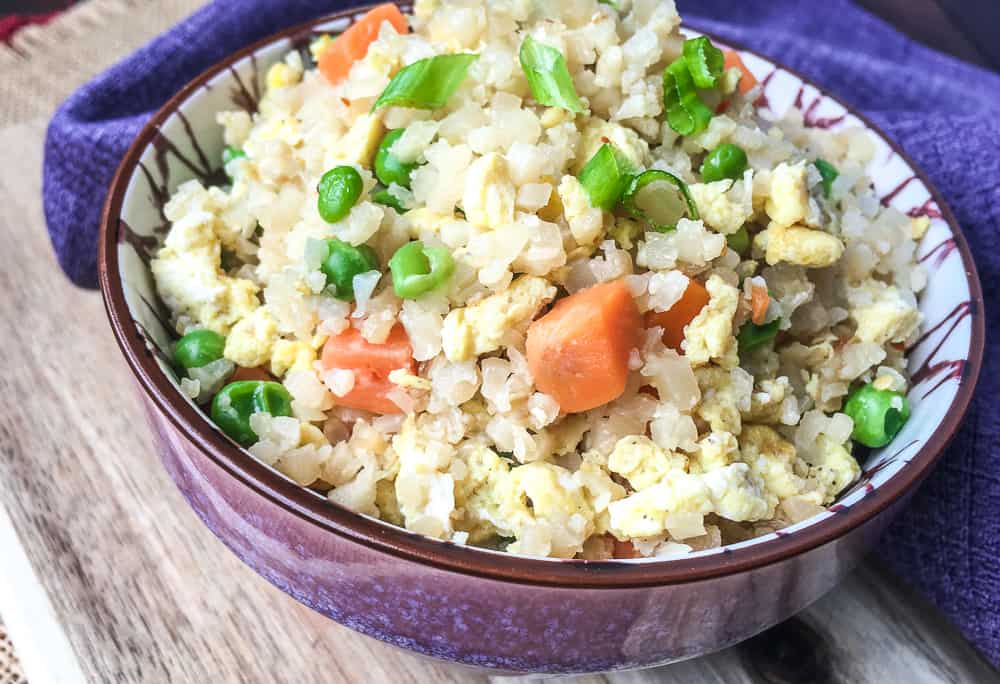 close up of Low Carb Cauliflower Fried Rice in brown and white ceramic bowl