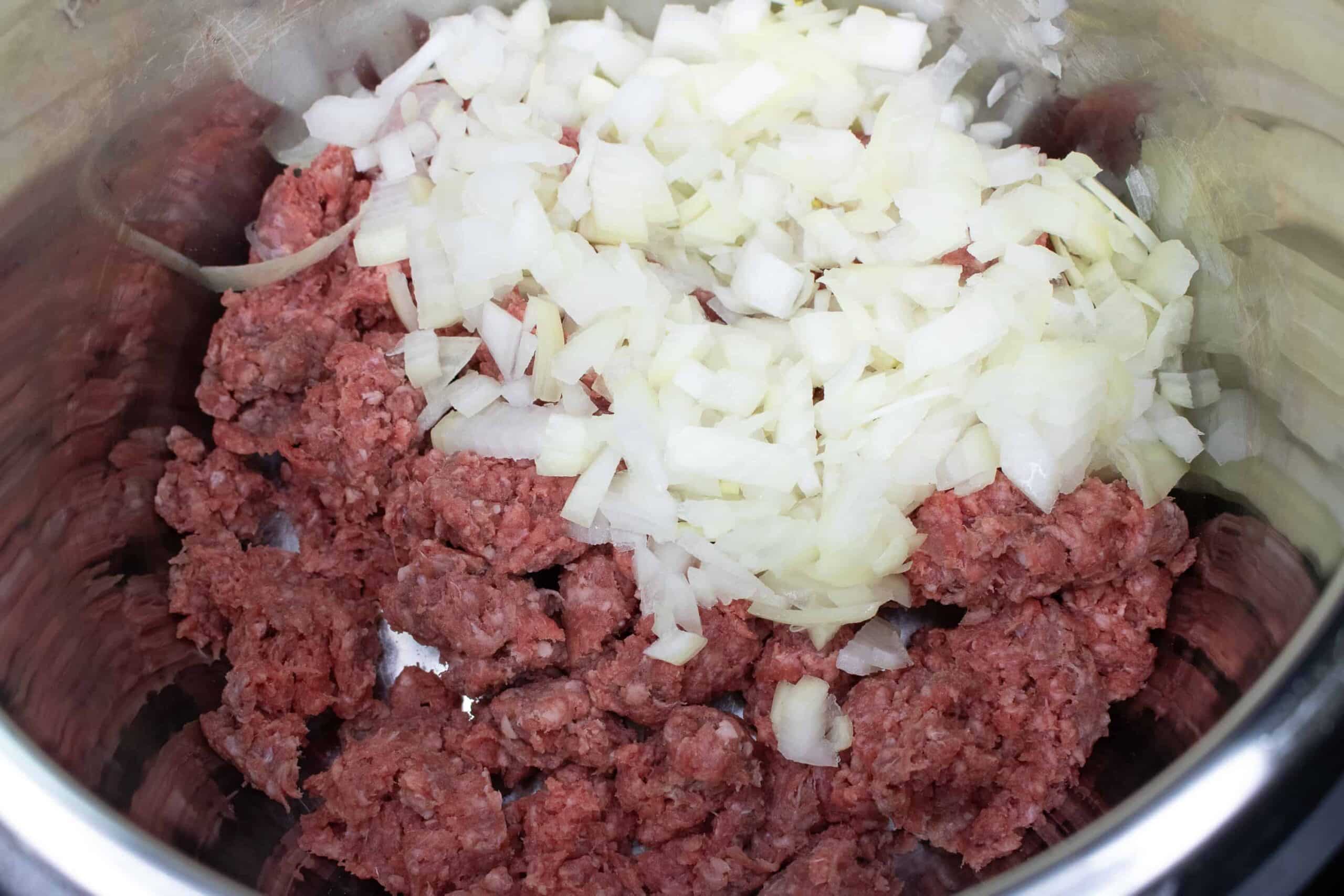 ground beef and diced onion inside the Instant Pot for making this Instant Pot Soup recipe