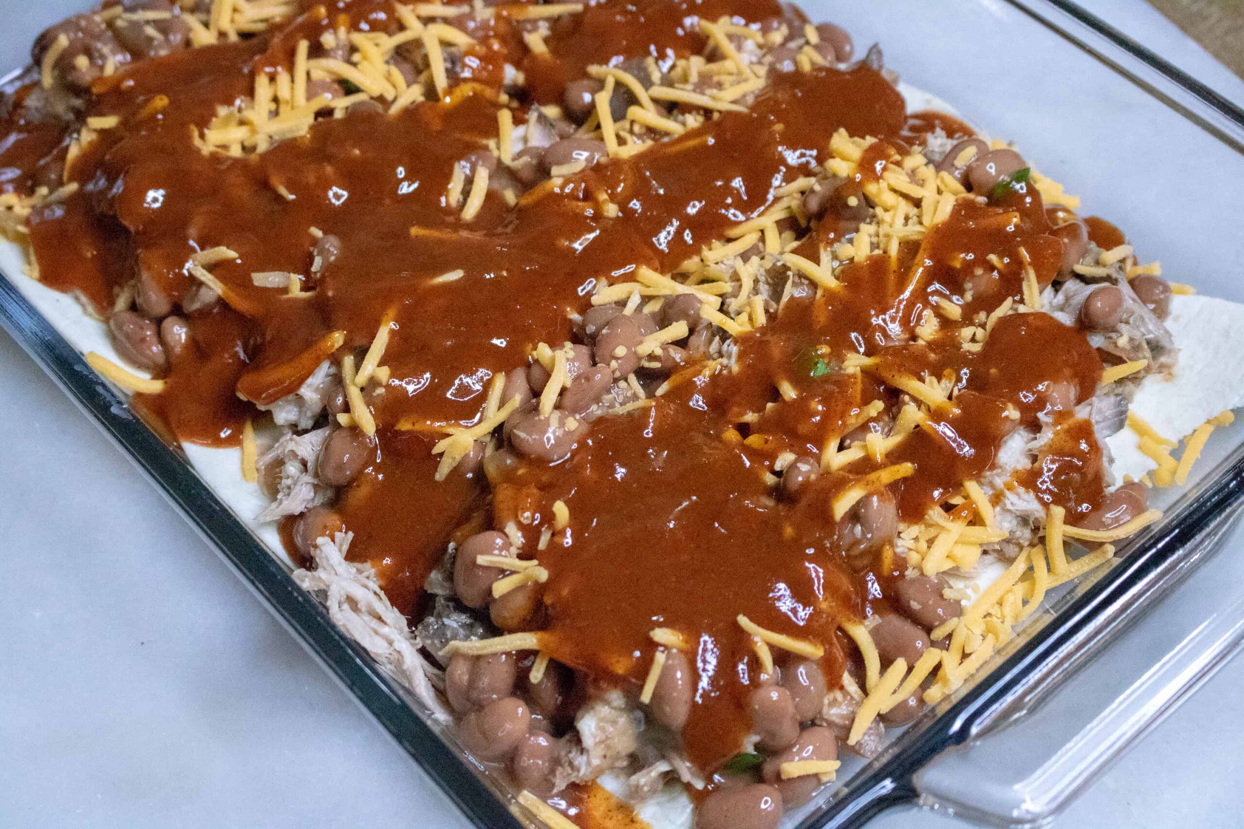 Pork Enchilada Casserole with assembled with all ingredients ready to be put into oven.