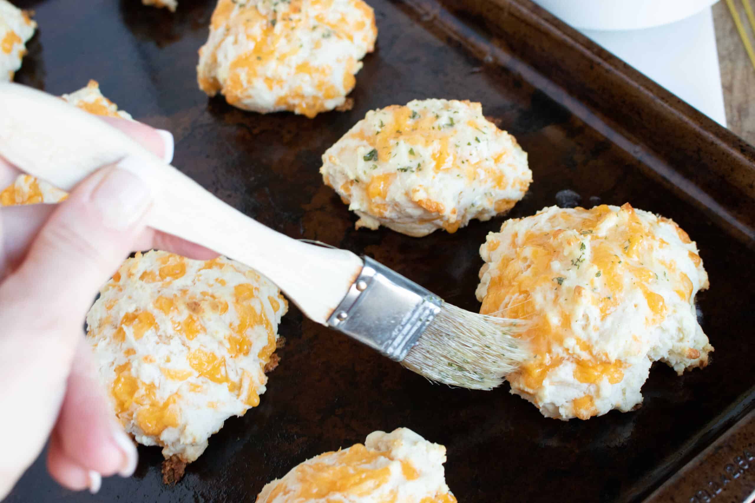 brushing the baked Red Lobster Copycat Biscuits with melted butter