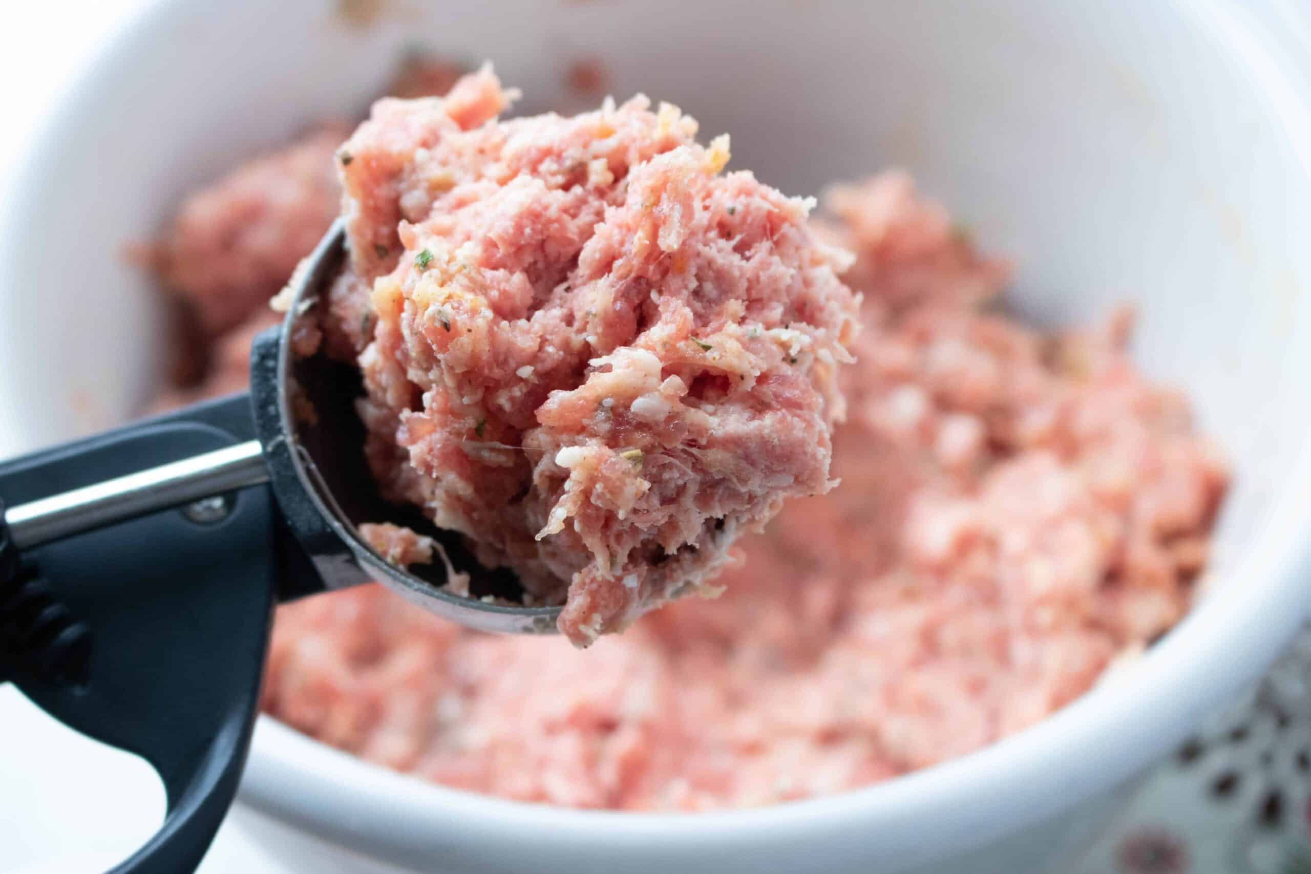 using a scoop to form meatballs for the Instant Pot Italian Meatball Sliders