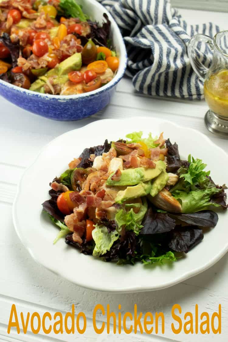 salad with chicken and bacon atop lettuce on a white plate