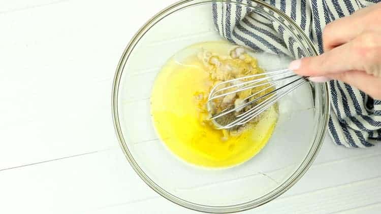 oil, garlic and seasonings in clear bowl with wire whisk