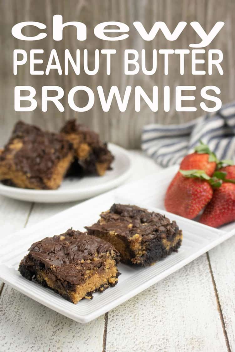 white plate with peanut butter brownies and strawberries in the background, along with a second plate with a stack of brownies