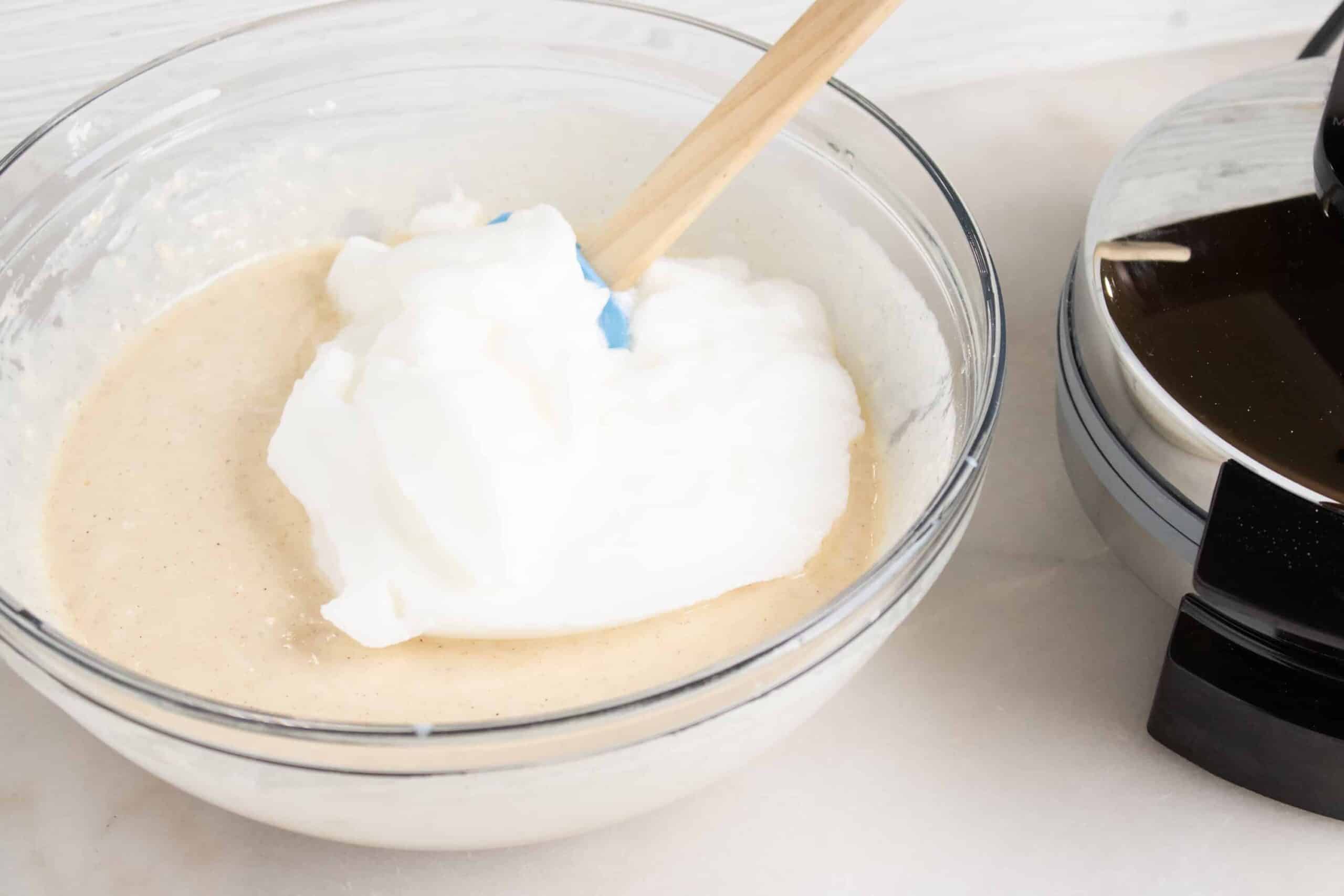 whipped egg whites in bowl with waffle batter