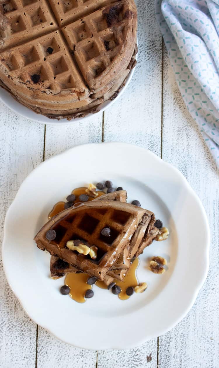 waffles quartered and stacked on a white plate shot from above