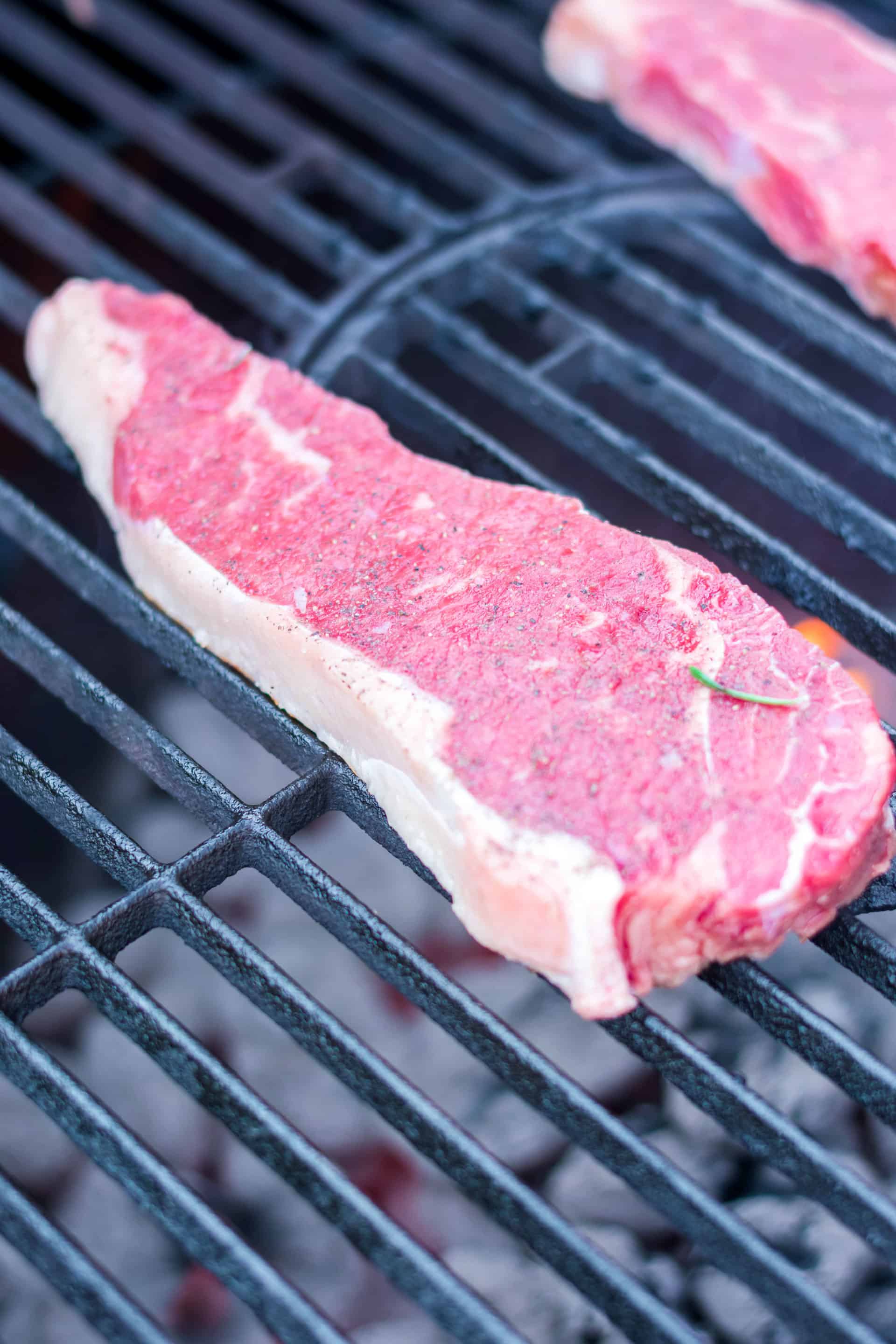 raw steaks on grill