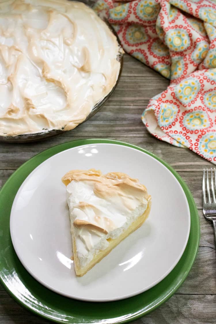 lemon meringue pie slice on a white and green plate