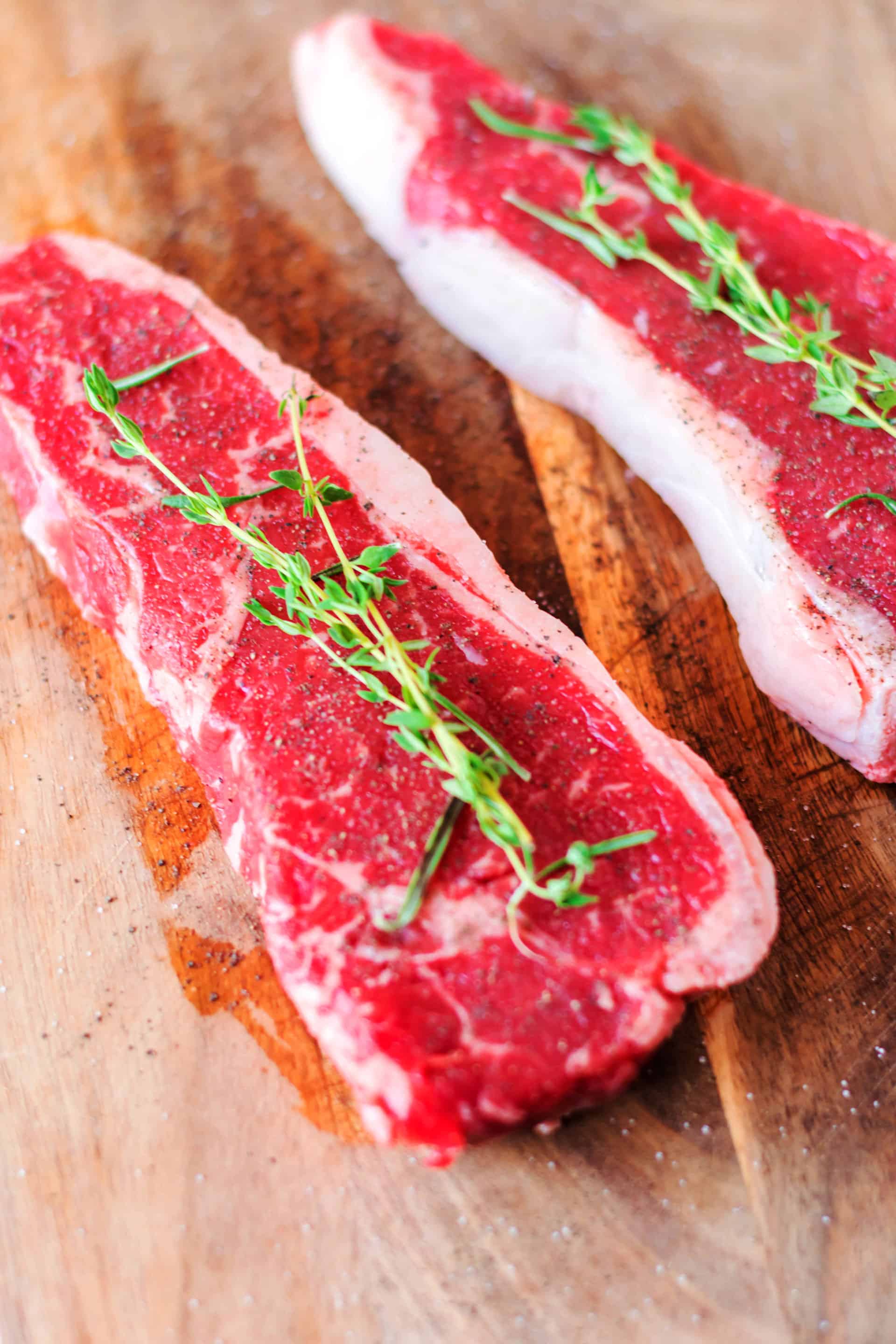 seasoned steaks on wood cutting board