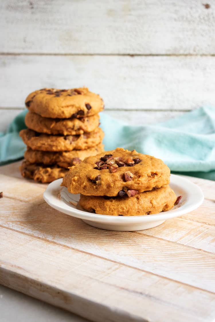 pumpkin chocolate chip cookies stacked on a plate